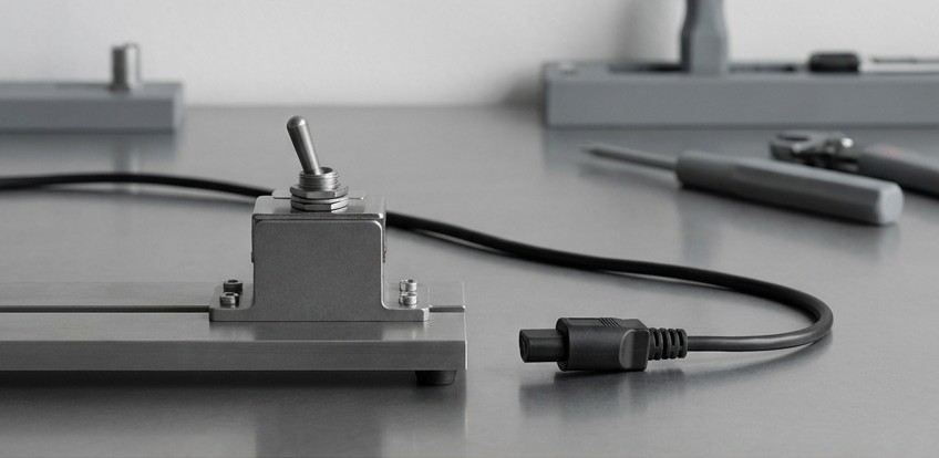 Conceptual AI illustration: A metal toggle fixture with its power connector unplugged.