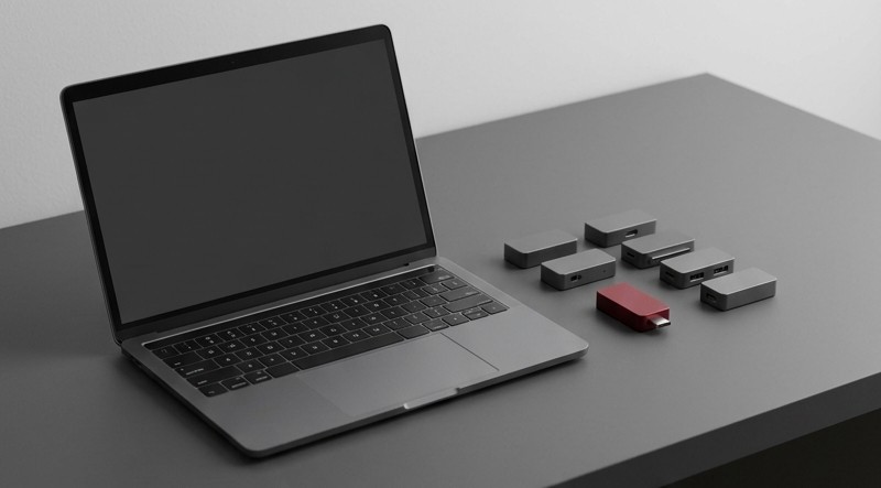 Conceptual AI illustration: A laptop beside several small graphite modules and one crimson module.
